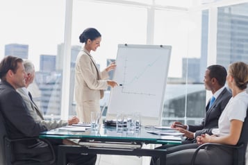 Businesswoman pointing at a growing chart during a meeting in the meeting room