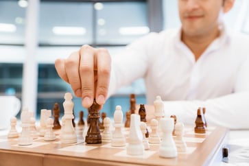 Two businessmen with chess in office